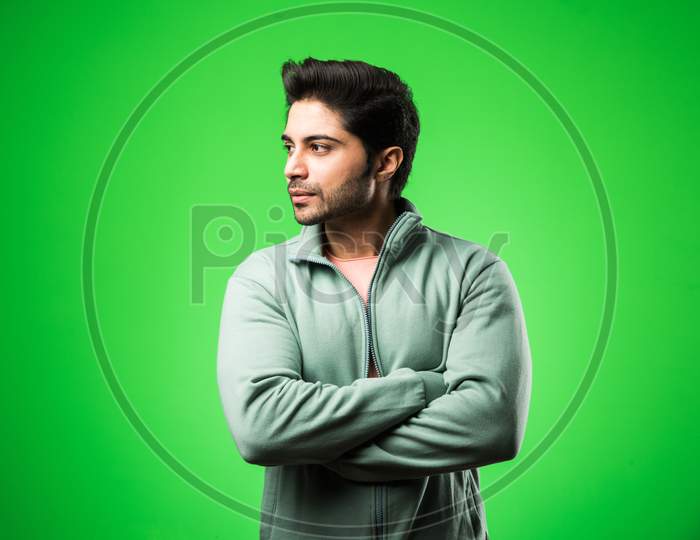Portrait of Indian Young Man, standing isolated over green chroma key background