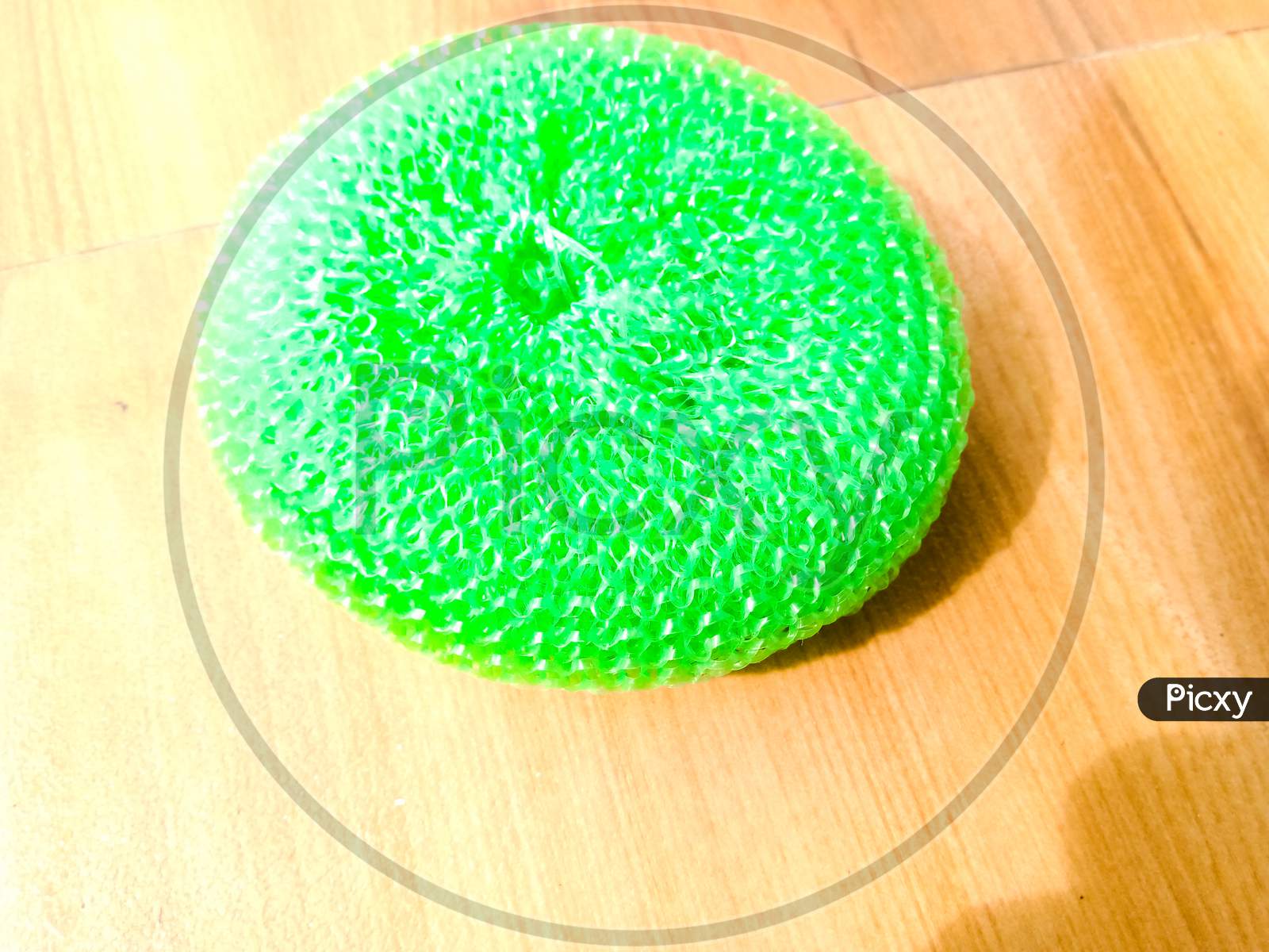 A Green Plastic Scrubber Placed On The Floor.