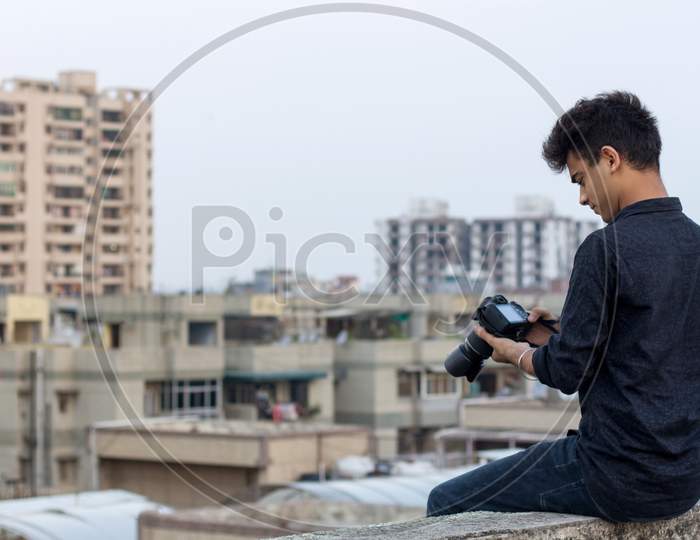 Young Photographer Clicking Photographs At Terrace During World Pandemic. Solo Explorer.