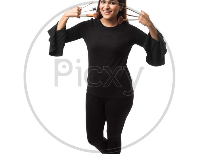 Indian young woman / Girl putting Makeup, standing isolated over white background