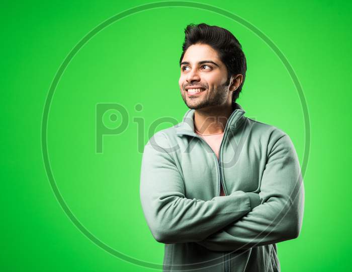 Portrait of Indian Young Man, standing isolated over green chroma key background