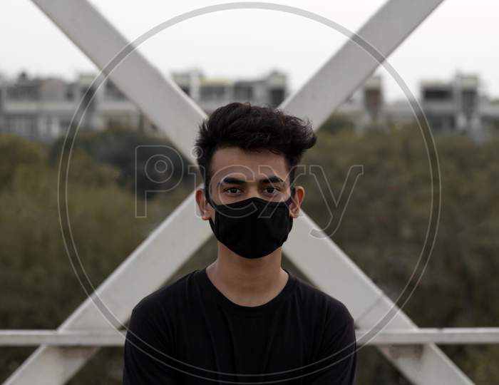 A Young Male Put A Mask On To Avoid Coronavirus Infection In A City.