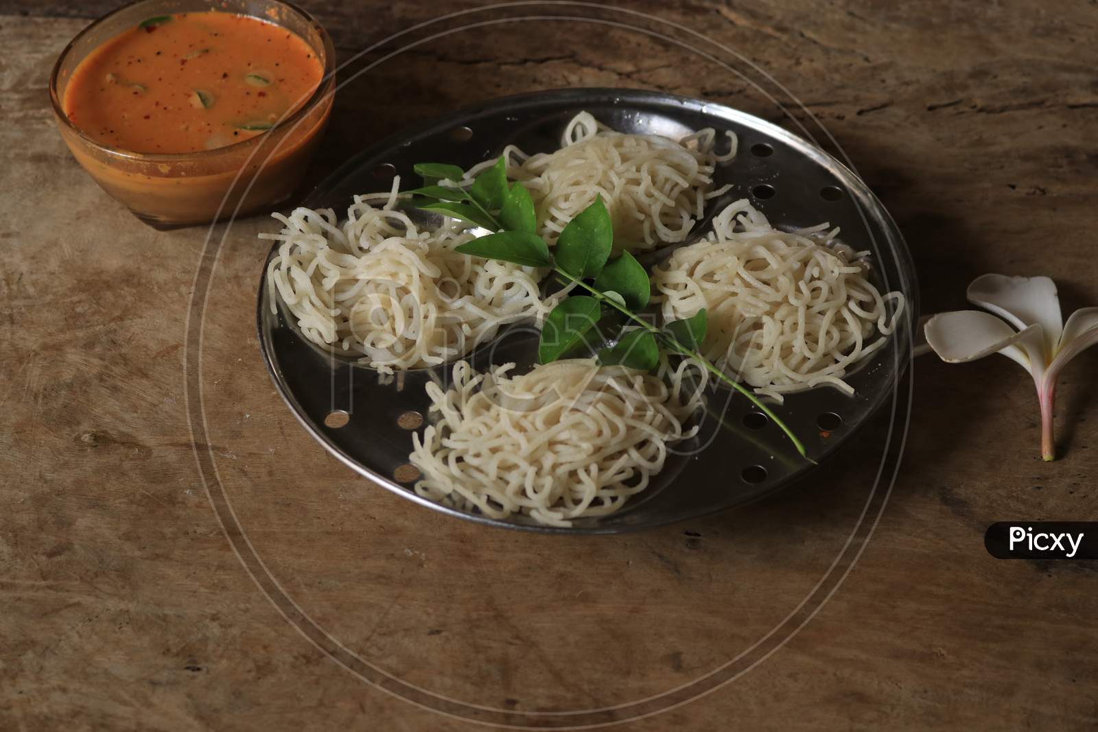 Rice Noodles in Idly Plate with Chutney Isolated with Wooden Background