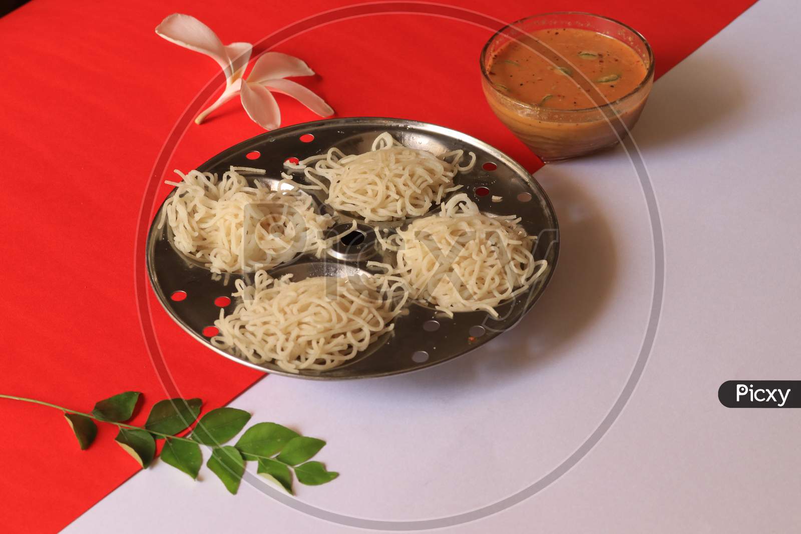 Rice Noodles in Idly Plate with Chutney Isolated with Red and White Background