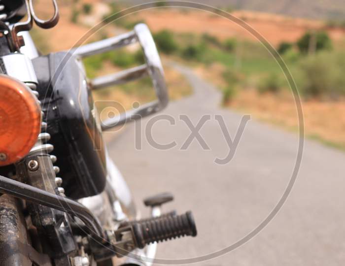 Selective on Royal Enfield Bike with Single Lane Road in the Background