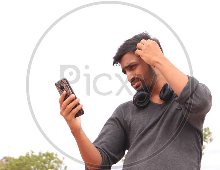 A Young Indian Man using a Smartphone or Mobile Phone