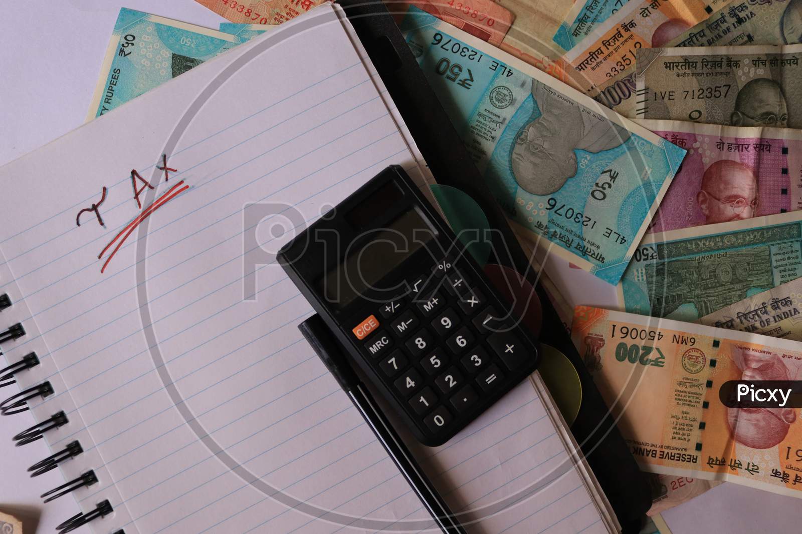 Indian Currency Coins and Notes with Calculator and A Book isolated with White Background