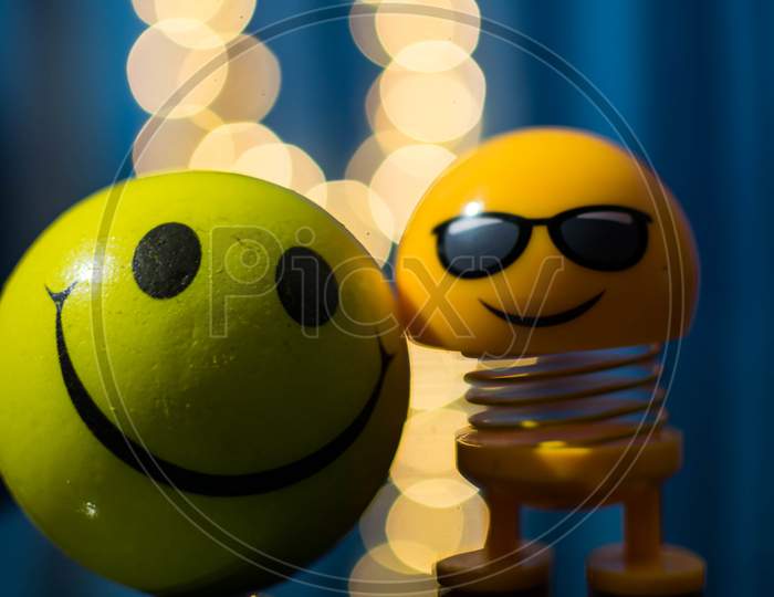 A Yellow Colored Toy And Smiley With Bokeh Background