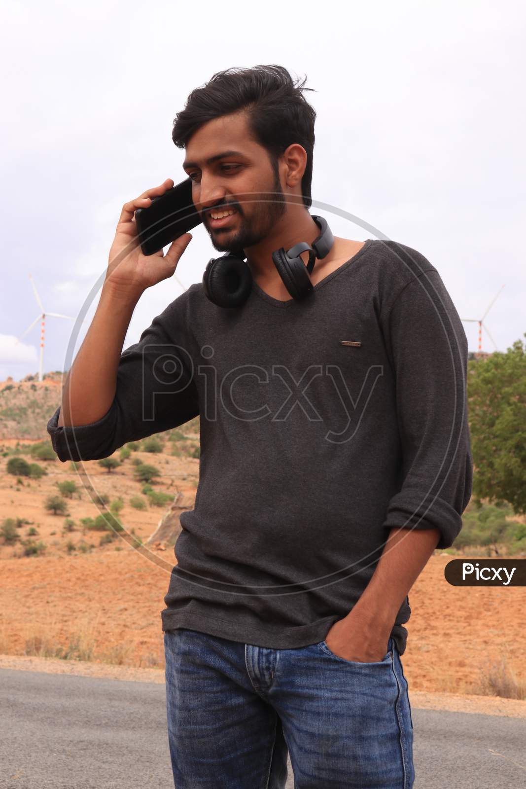 A Young Indian Man talking using a Smartphone or Mobile Phone