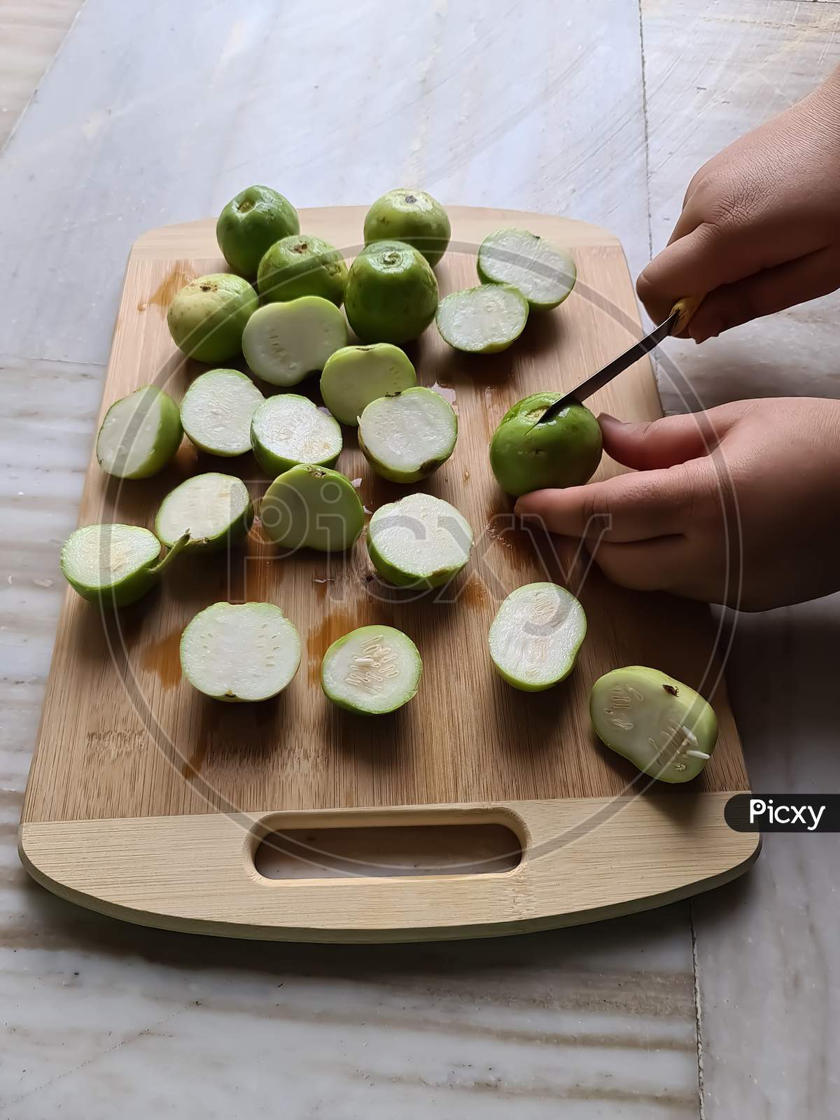 Round gourds cutting on chopping board with knife