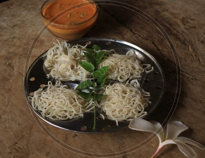 Rice Noodles in Idly Plate with Curry Isolated with Wooden Background