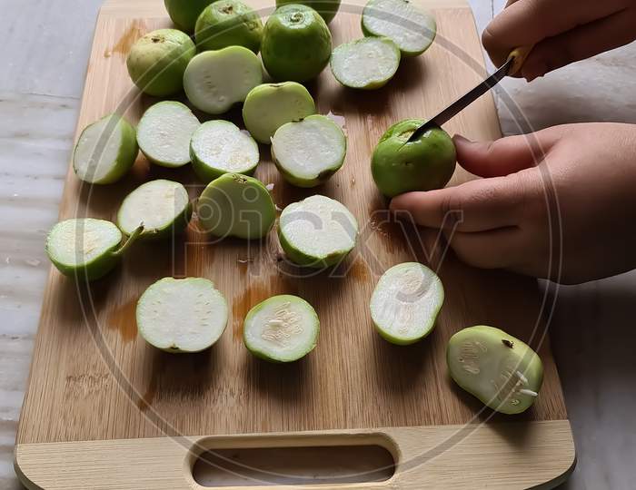 Round gourds cutting on chopping board with knife