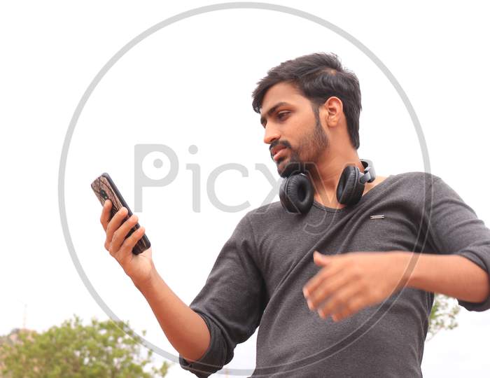 A Young Indian Man using a Smartphone or Mobile Phone