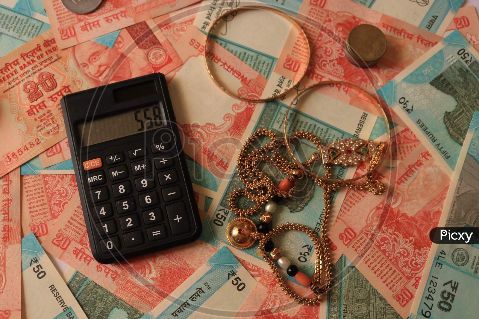 Indian Currency Notes with Calculator and Gold Ornaments