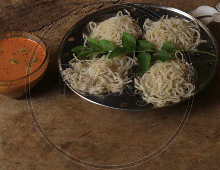 Rice Noodles in Idly Plate with Chutney Isolated with Wooden Background