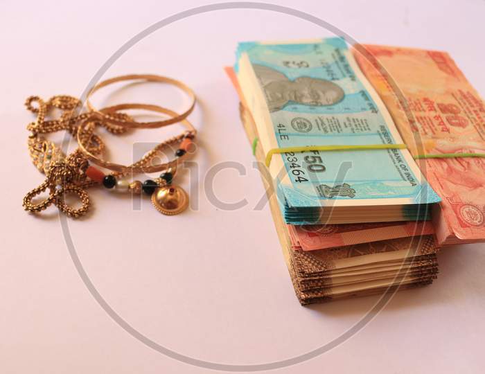 Indian Currency Notes with Gold Ornaments isolated with White Background