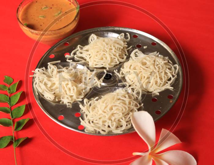 Rice Noodles in Idly Plate with Chutney Isolated with Red Background