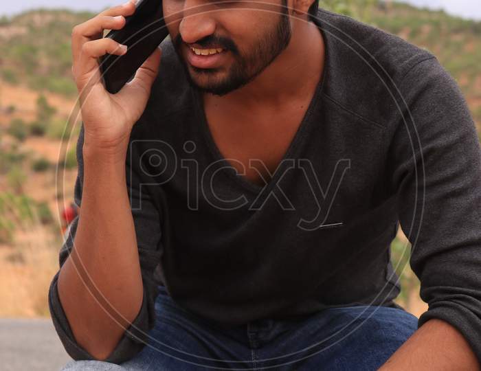 Portrait of a Young Indian Man Talking using a Smartphone or Mobile Phone