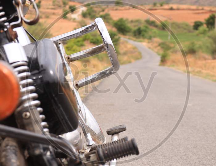 Selective on Royal Enfield Bike with Single Lane Road in the Background