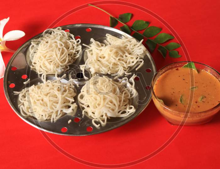 Rice Noodles in Idly Plate with Chutney Isolated with Red Background