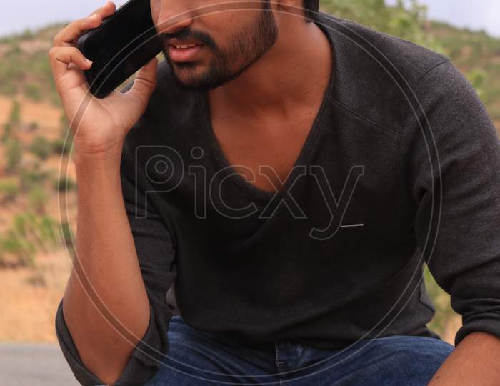 Portrait of a Young Indian Man Talking using a Smartphone or Mobile Phone
