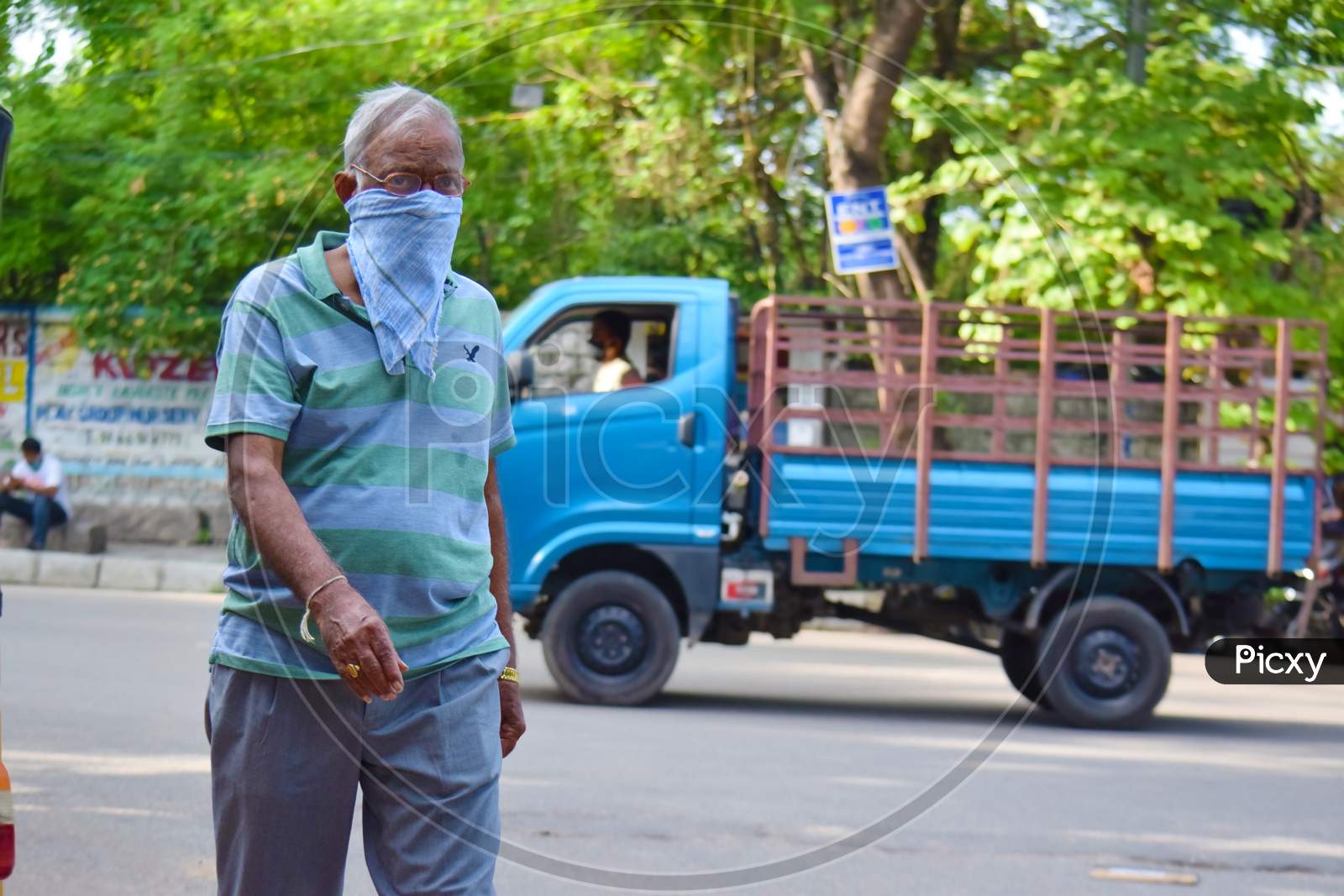 Hyderabad, Telangana, India. july-14-2020: an older man is walking on the road. man with protective safety mask on his face in the city on a sunny day