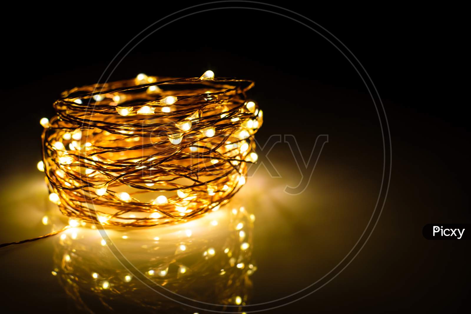 Yellow Colored Light Chain For Decoration Placed On A Reflective Surface