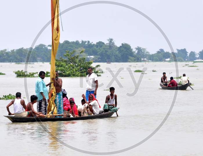 Villagers navigate a flooded area in a boat in Jhargaon in Morigaon, Assam on July 14, 2020