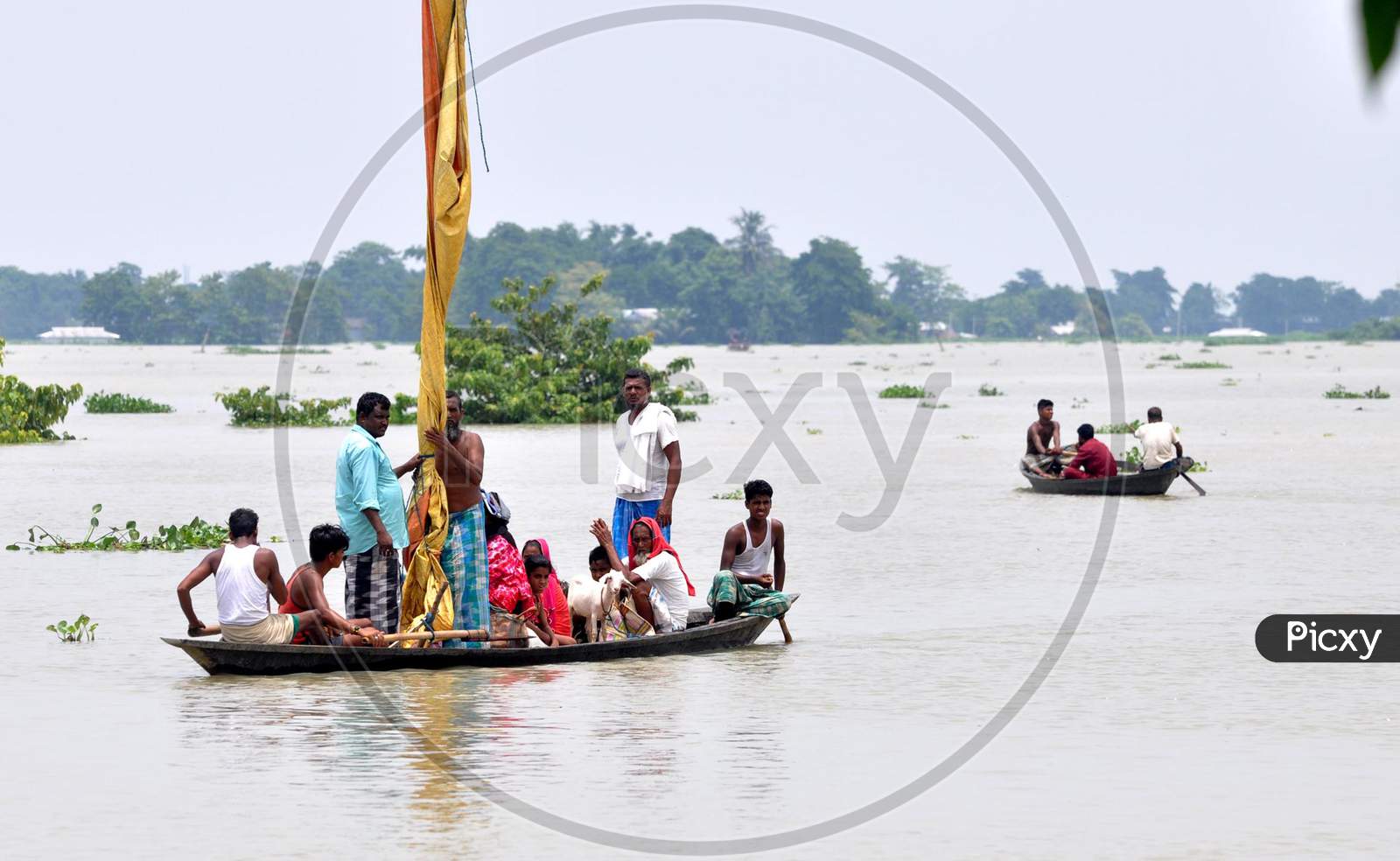 Villagers navigate a flooded area in a boat in Jhargaon in Morigaon, Assam on July 14, 2020