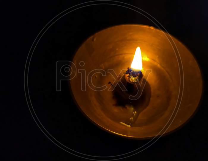 Close up of the flame of diyas in black dark background at night. Selective focus on flame.