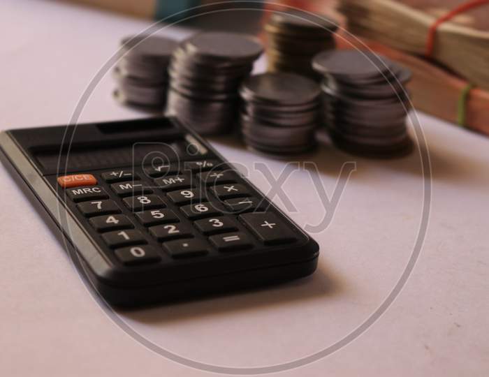Indian Currency Coins and Notes with Calculator isolated with White Background