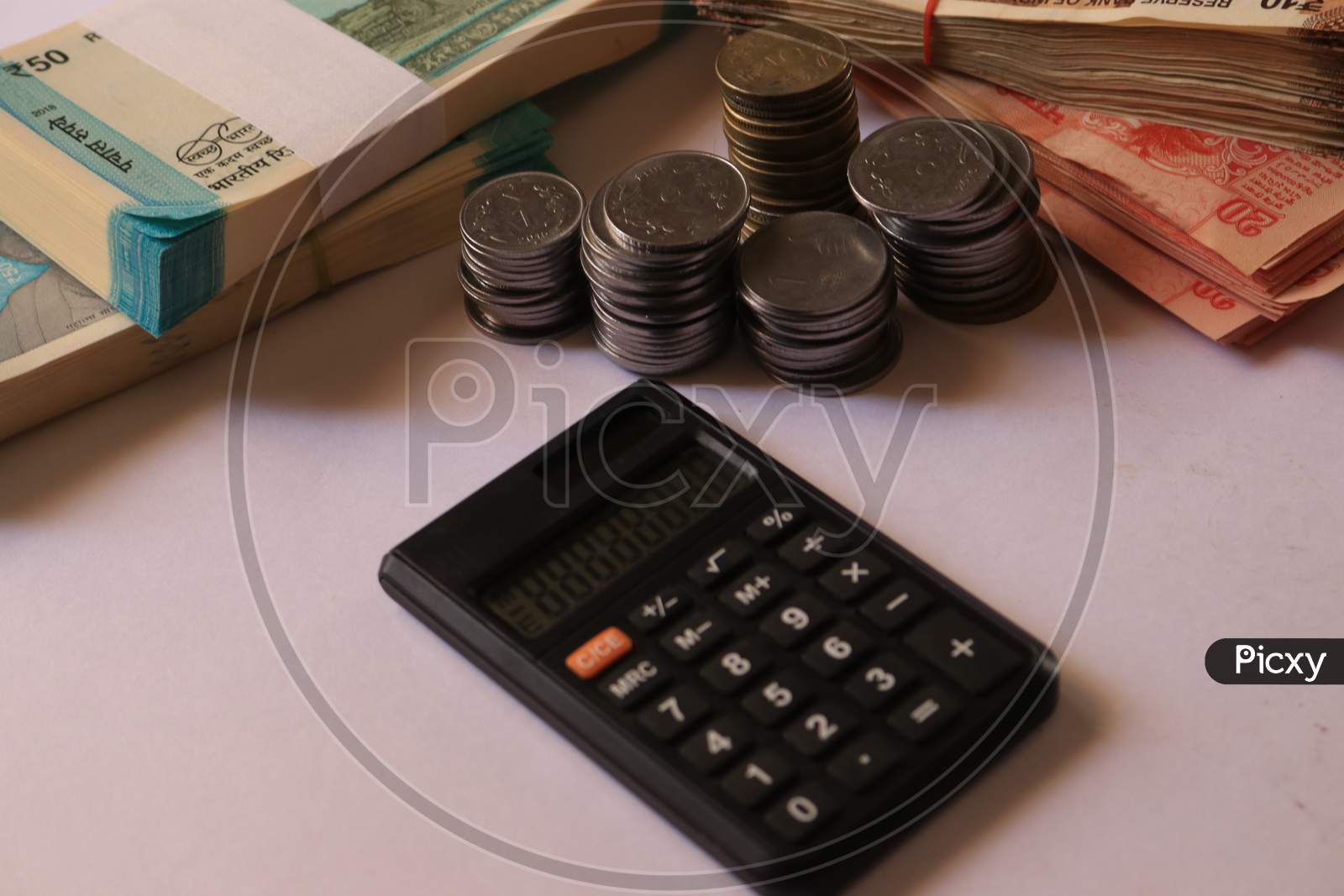 Indian Currency Coins and Notes with Calculator isolated with White Background
