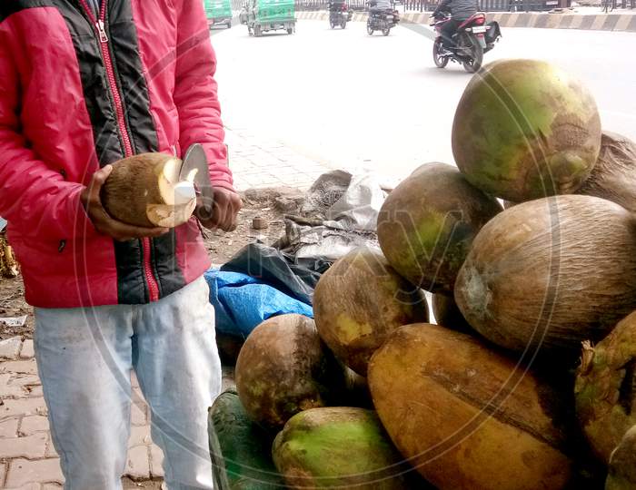 Mumbai, India - December, 2019: Street Vendor - Close-Up Of Man Cutting Tender Coconut