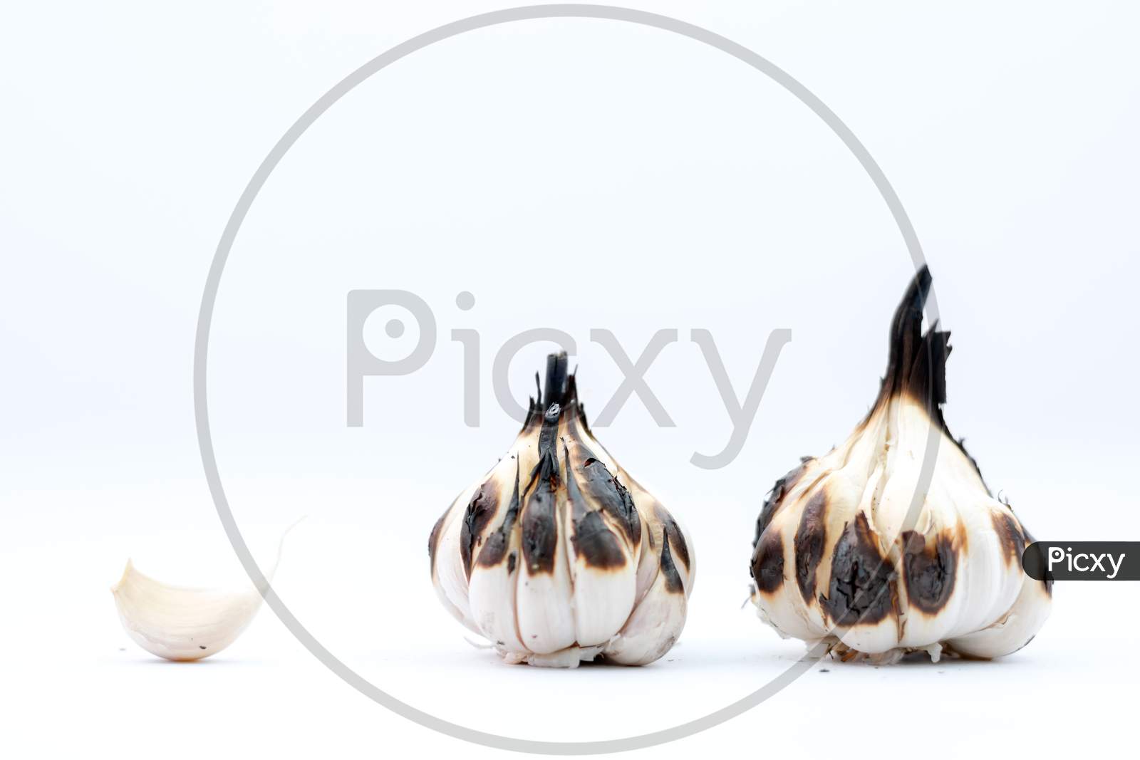 Roasted Garlic Cloves And Bulb In White Background.