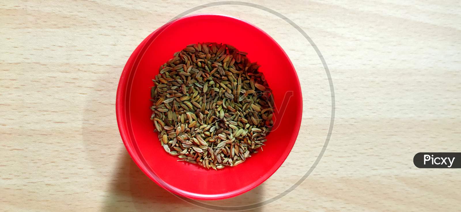 Fennel seeds in red bowl