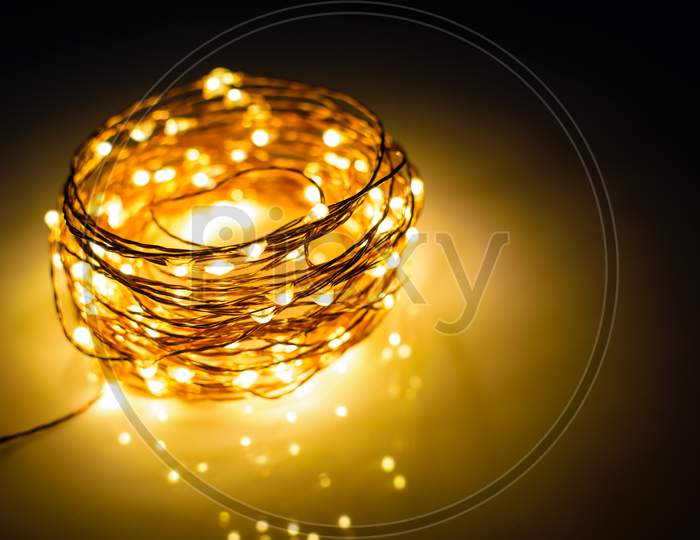 Yellow Colored Light Chain For Decoration Placed On A Reflective Surface