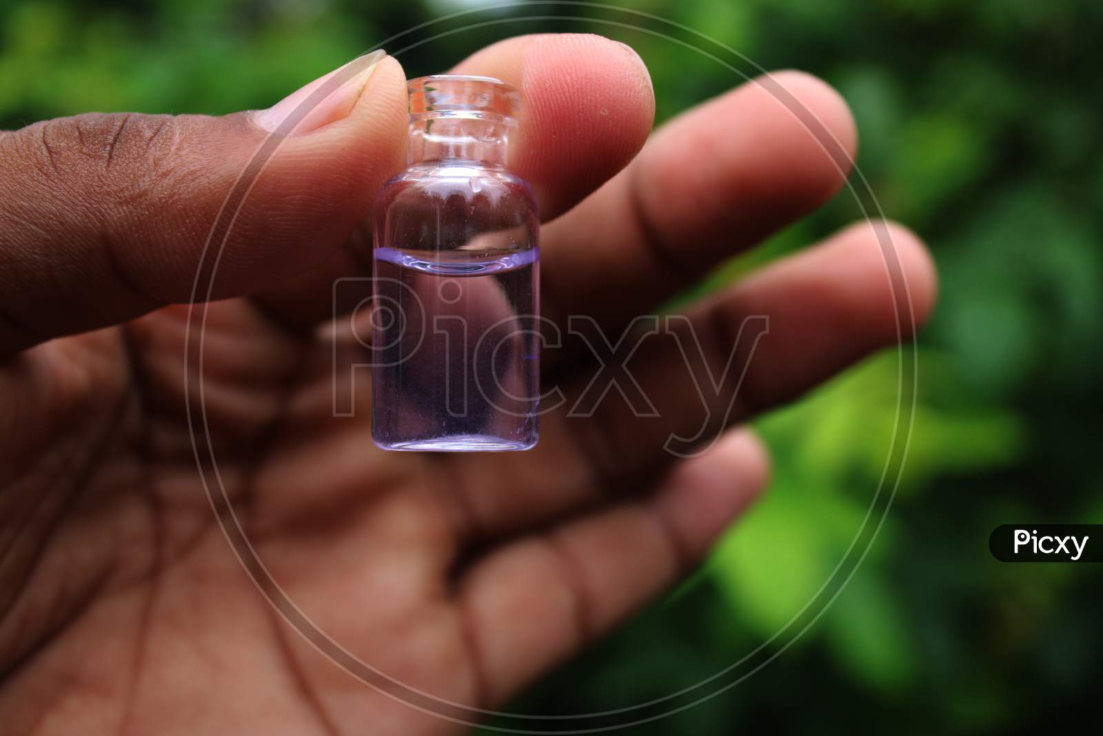 Water in the small bottle on the hand natural photo