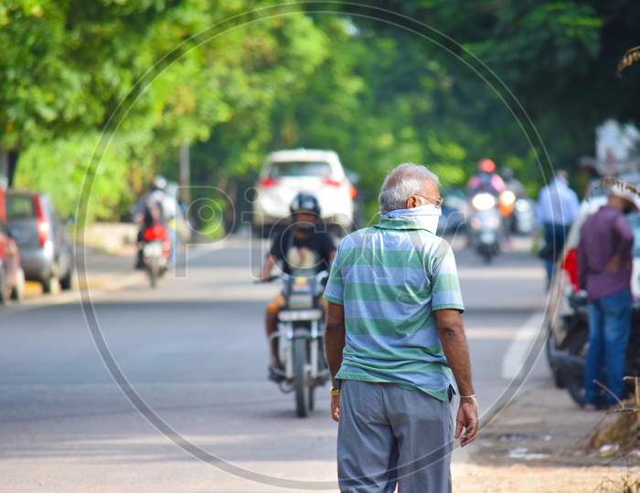 Hyderabad, Telangana, India. july-14-2020: an older man is walking on the road. man with protective safety mask on his face in the city on a sunny day