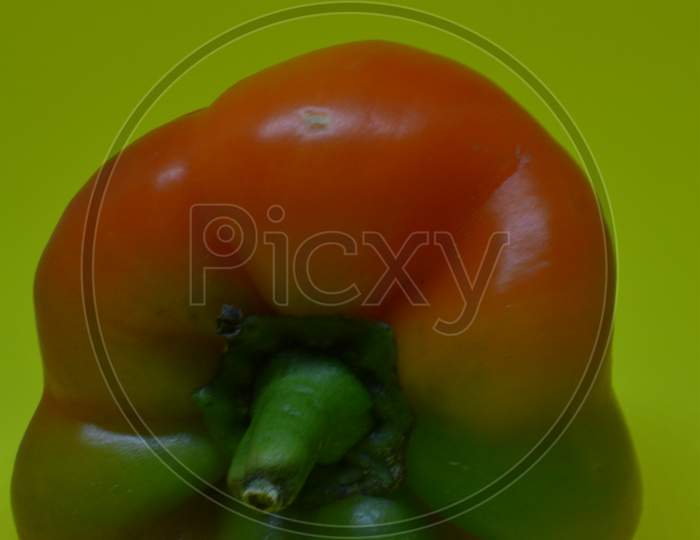 Green Yellow Paprika Or Capsicum In Yellow Isolated Background.