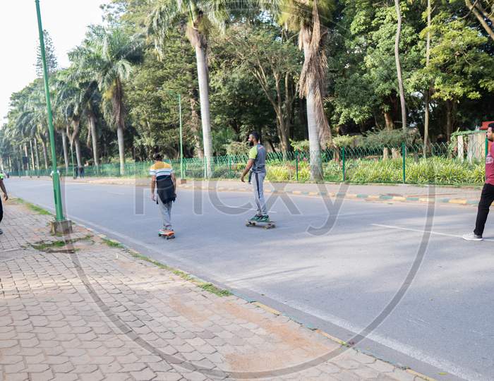 Cubbon Park,Bangalore,India-30Th November 2019 - Two Young Citizens Going On A Skate Board In Cubbon Park