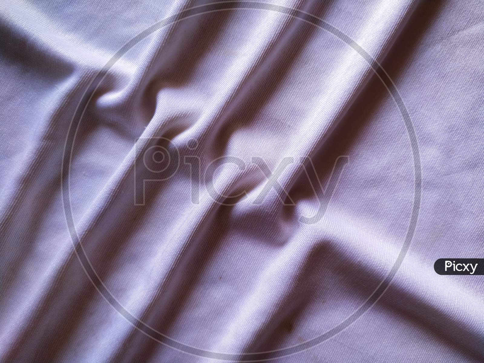 Elegant soft foldings of silk fabric with tint of pink.