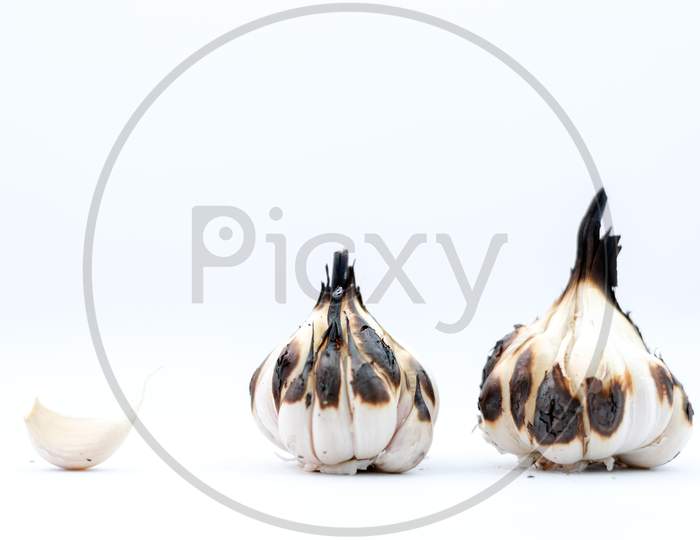 Roasted Garlic Cloves And Bulb In White Background.