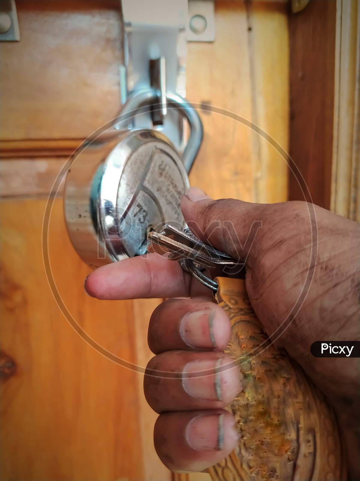A repairman unlocking the lock with holding in dirty hand key at door opening