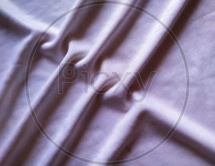 Elegant soft foldings of silk fabric with tint of pink.