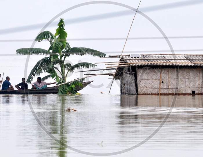 People navigate the flood-affected areas using a boat in Hatisela in Kamrup district of Assam on July 14, 2020
