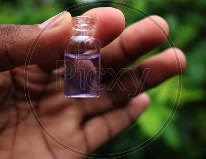 Water in the small bottle on the hand natural photo