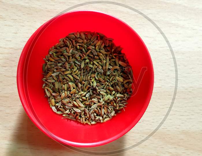 Fennel seeds in red bowl