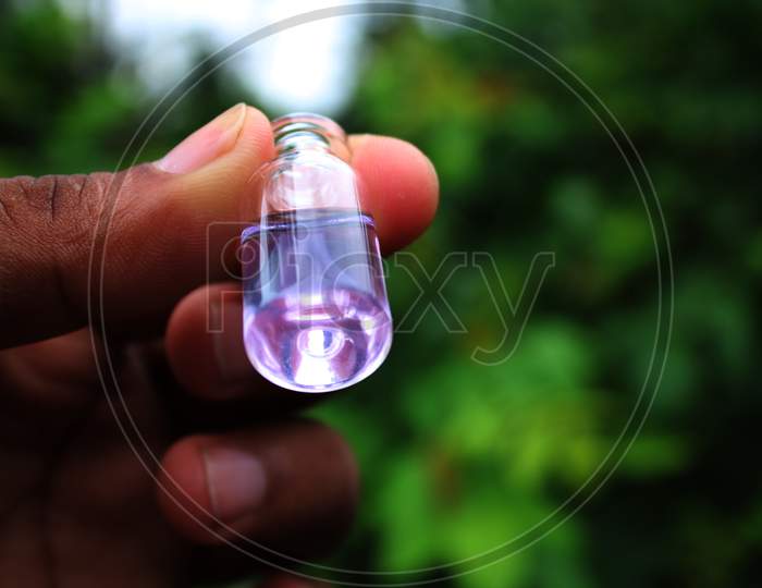 Water in the small bottle on the hand