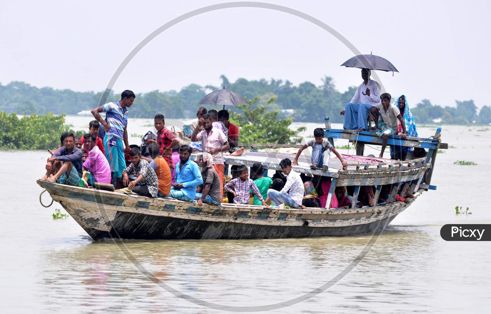 Villagers cross a flooded area in a boat at Jhargaon in Morigaon, Assam on July 14, 2020