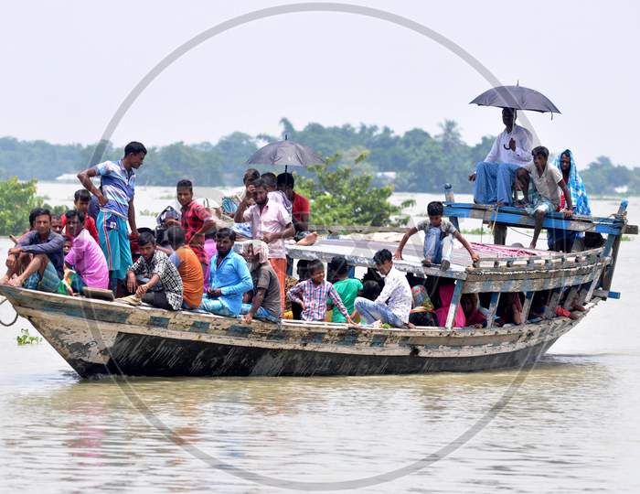 Villagers cross a flooded area in a boat at Jhargaon in Morigaon, Assam on July 14, 2020